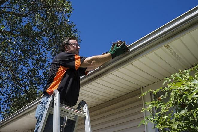 dirty gutter being unclogged and repaired in Atlas